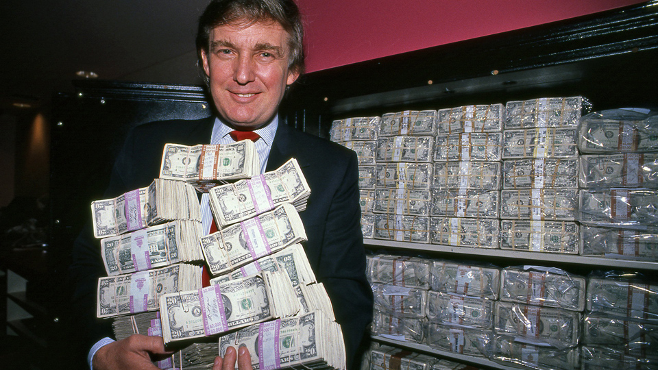 Donald Trump surrounded by money representing the Trump family's financial enrichment during his second presidency