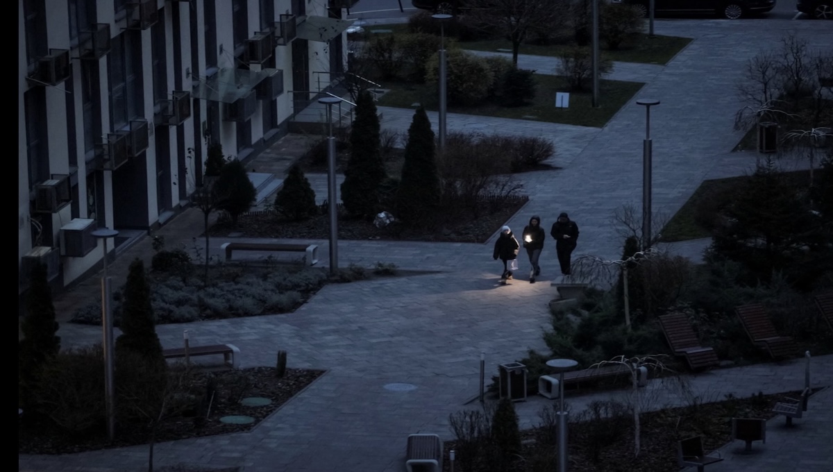 Ukrainians walking through dark streets during a winter power blackout caused by Russian strikes