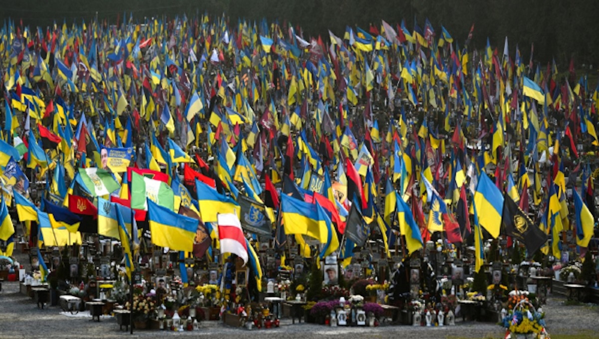 Hundreds of Ukrainian military graves covered in national flags at a memorial cemetery