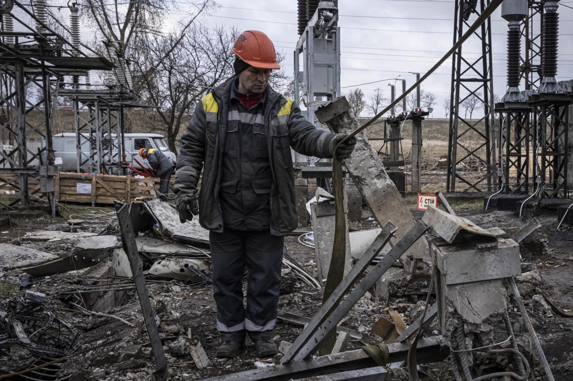 Workers assessing damage to a destroyed Ukrainian power substation following Russian missile strikes